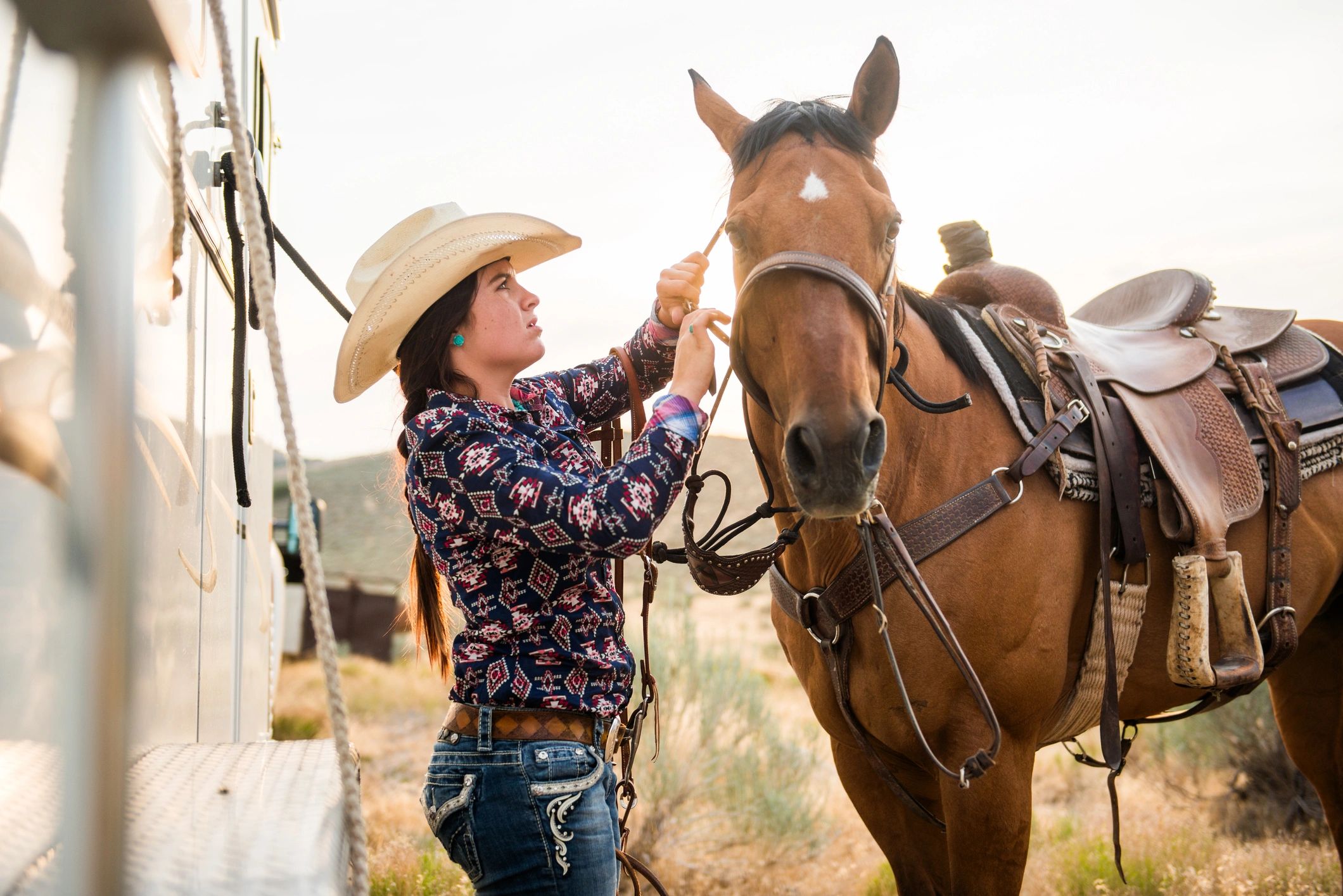 Rider preparing horse at sunset